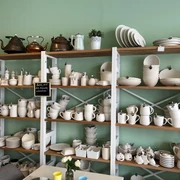 Lieblingstasse-Rohkeramik.jpg Regale mit verschiedenen Keramikwaren, darunter Kannen und Tassen