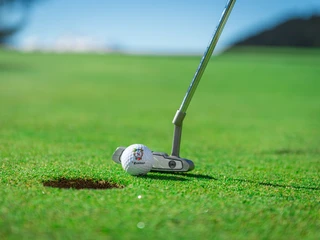 Putt auf dem Grün in der Aletsch Arena Golf Schnupperkurs Aletsch Arena mit Nahaufnahme eines Putts auf dem Grün des Golfplatzes Riederalp