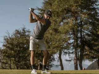 Golfer beim Abschlag auf der Riederalp Golf Schnupperkurs Aletsch Arena mit Spieler beim kraftvollen Abschlag auf dem Golfplatz Riederalp in den Alpen