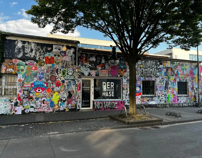 Der schwarze Hase Graffiti-bedeckte Fassade eines Gebäudes in urbaner Umgebung mit teils farbenfrohen Motiven.Graffiti-covered facade of a building in an urban environment with partly colorful motifs.