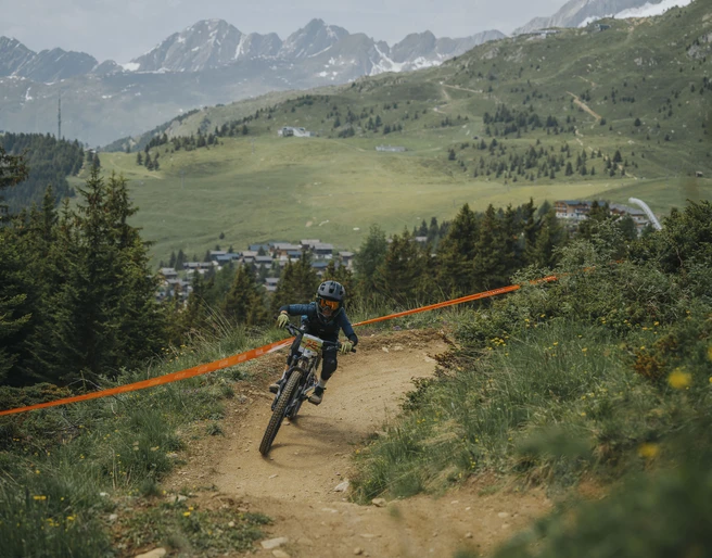 Enfant lors d'une course de VTT à Bettmeralp Kinderbikekurs Bettmeralp mit junger Teilnehmerin auf dem Flowtrail vor der Bergkulisse der Aletsch ArenaBettmeralp children's bike course with a young participant on the flow trail against the mountain backdrop of the Aletsch ArenaCours de VTT pour enfants à Bettmeralp avec une jeune participante sur le flowtrail devant le décor montagneux de l'Aletsch Arena
