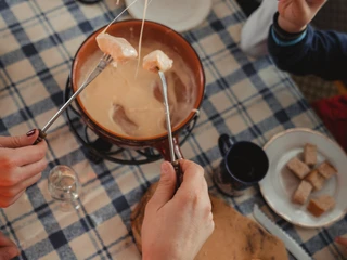 Familienfondue in der Aletsch Arena Fondue oder Racletteplausch Aletsch Arena mit Familie beim gemeinsamen Käsefondue im Restaurant Chüestall auf der Riederalp