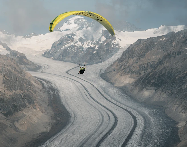Paragliding on the Aletsch Glacier Aletsch Fly Deluxe Gleitschirmflug über den Grossen Aletschgletscher mit Pilot und Passagier vor eindrucksvoller GletscherkulisseAletsch Fly Deluxe paragliding flight over the Great Aletsch Glacier with pilot and passenger against an impressive glacier backdropAletsch Fly Deluxe Vol en parapente au-dessus du grand glacier d'Aletsch avec pilote et passager devant un impressionnant décor de glacier