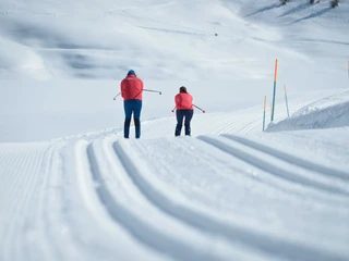 Langlaufen auf frisch gespurter Loipe Langlauf Schnupperkurs Bettmeralp in der Aletsch Arena mit zwei Teilnehmern auf frisch präparierter Loipe im Winter