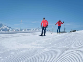 Cross-country skiing on freshly groomed trails Langlauf Schnupperkurs Bettmeralp in der Aletsch Arena mit Technikübungen auf der Loipe vor AlpenpanoramaCross-country skiing taster course Bettmeralp in the Aletsch Arena with technique exercises on the cross-country ski trail in front of an Alpine panoramaCours d'initiation au ski de fond à Bettmeralp dans l'Aletsch Arena avec exercices techniques sur la piste devant un panorama alpin