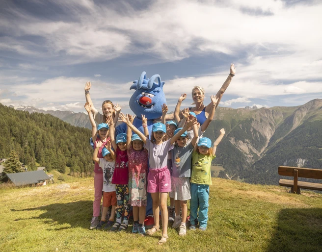 Kindergruppe mit Gletschi in den Alpen Gletschi Programm Aletsch Arena mit fröhlicher Kindergruppe und Maskottchen Gletschi beim Spielen auf der Bettmeralp im Sommer
