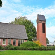 Friedenskirche Augustfehn Die Friedenskirche Augustfehn ist ein eindrucksvoller roter Backsteinturm, umgeben von grünen Büschen und Bäumen