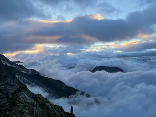 Morgenstimmung über der Aletsch Arena Nachtwanderung Bettmeralp Belalp mit Blick auf die nebelverhangenen Berge im ersten Licht des Tages über der Aletsch Arena
