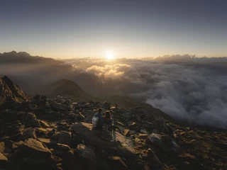 Sonnenaufgang über dem Wallis Sonnenaufgangsfahrt Eggishorn mit Blick über das Wolkenmeer und goldene Sonnenstrahlen über den Walliser Alpen