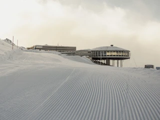 Erste Spuren im Schnee am Bettmerhorn First Track Bettmerhorn mit frisch präparierter Skipiste bei Morgendämmerung und Blick auf die Bergstation