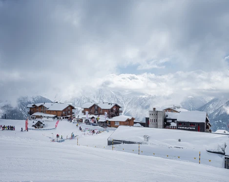 École de ski à Fiescheralp en hiver Ski Schnupperkurs Fiescheralp mit Blick auf Skischulgelände und Chalets im verschneiten BergdorfFiescheralp ski taster course with a view of the ski school grounds and chalets in the snow-covered mountain villageCours d'initiation au ski Fiescheralp avec vue sur le terrain de l'école de ski et les chalets du village de montagne enneigé