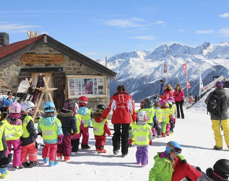 Kinder-Skikurs auf der Fiescheralp Ski Schnupperkurs Fiescheralp mit Skilehrerin und Kindern vor der Schweizer Skischule Fiesch bei Sonnenschein