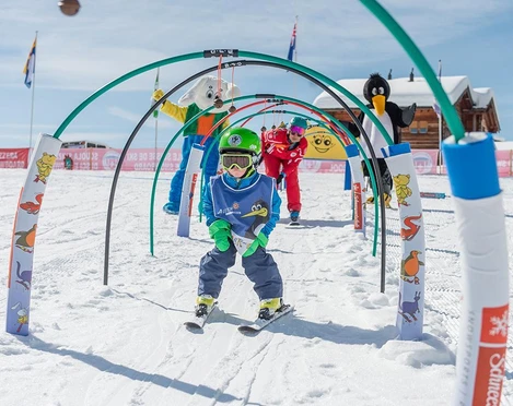 Kinder lernen Skifahren auf der Riederalp Ski Schnupperkurs Riederalp mit Kind im Kinderland der Schweizer Skischule unter Anleitung und Maskottchen