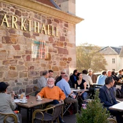 Markthalle in Kassel im Sommer Vor der Markthalle sitzen Personen auf der Terrasse im Sommer. People sit on the terrace in front of the market hall in summer.