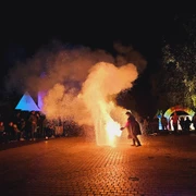 Feuershow der Rasteder Lichternacht.jpg Feuershow in der Nacht mit Funkenregen, umgeben von Zuschauern und bunt beleuchteten Zelten.