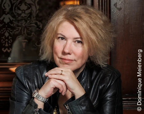 Nina George Eine Frau mit blonden Haaren in einer schwarzen Lederjacke blickt direkt in die Kamera.A woman with blonde hair in a black leather jacket looks directly into the camera.