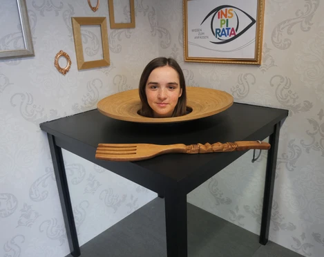 Die INSPIRATA - Optische Täuschung Der Kopf einer jungen Frau liegt in einer optischen Täuschung in der INSPIRATA scheinbar auf einem Teller auf einem Tisch