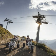 Mountaincart unter der Gletscherbahn Moosfluh Junge Fahrer erleben das Mountaincart Aletsch Arena bei einer rasanten Abfahrt unter der Gondelbahn der Riederalp