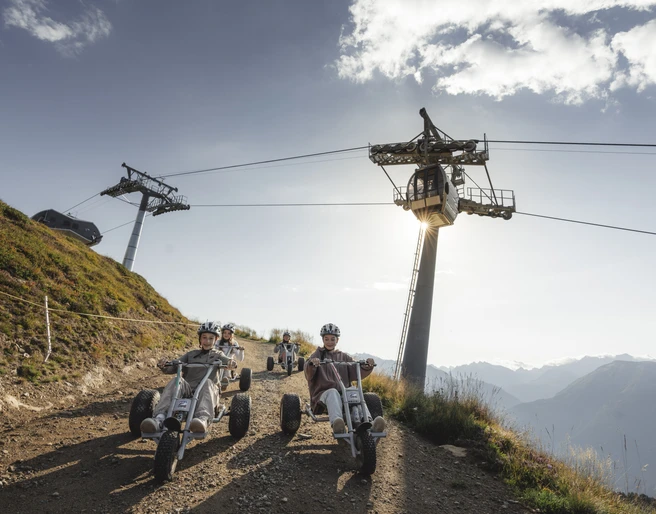Mountaincart unter der Gletscherbahn Moosfluh Junge Fahrer erleben das Mountaincart Aletsch Arena bei einer rasanten Abfahrt unter der Gondelbahn der Riederalp