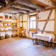 Stube in der Obermühle Bad Düben In einem historischen Raum mit Holzbalken und rustikalem Holzfußboden steht ein gedeckter Tisch in der Obermühle Bad Düben.
