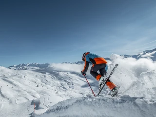 Skisprung auf der sonnigen Piste der Aletsch Arena Beim Wahltages Skipass Aletsch Arena springt ein Skifahrer mit Schwung über eine Schneekante und geniesst den Moment in der klaren WinterluftOn the Aletsch Arena ski pass, a skier leaps over a snow edge and enjoys the moment in the clear winter airLors de la journée de choix du forfait de ski Aletsch Arena, un skieur saute avec élan par-dessus une arête de neige et savoure le moment dans l'air pur de l'hiver.