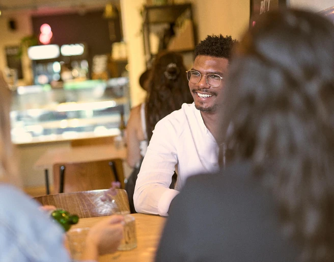 Das KAFF, Mülheim an der Ruhr Ein helles Café mit freundlicher Atmosphäre. Gäste sitzen entspannt miteinander an Holztischen.