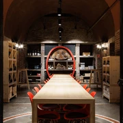 Cologne wine cellar Langer Holztisch mit roten Stühlen in einem stimmungsvoll beleuchteten Weinkeller.Long wooden table with red chairs in an atmospherically lit wine cellar.