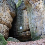 Eingang Götzinger Höhle an den Bärensteinen Hohe Sandsteinfelsen umgeben einen schmalen Durchgang in einem Wald.