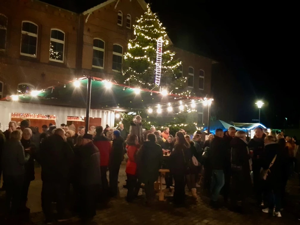 Weihnachten mit dem OBV Apen Menschenmenge bei Nacht auf einem festlich beleuchteten Weihnachtsmarkt vor einem großen Baum.