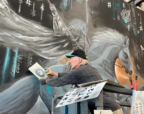 Thomas Baumgärtel Thomas Baumgärtel arbeitet an einem großen Wandbild: Ein Reiter auf einem imposanten Pferd, umgeben von Tech-Symbolen.Thomas Baumgärtel is working on a large mural: a rider on an imposing horse, surrounded by tech symbols.