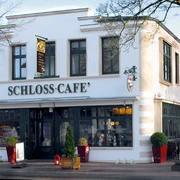 Aussenaufnahme vom Schloss-Café Zweistöckiges Gebäude mit heller Fassade und großen Fenstern, Eingang zum Schloss-Café.