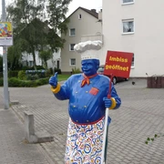 riedels-grilleck-aufsteller Lebensgroße blaue Kochfigur am Straßenrand