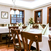 fs-raum Ein stilvoll eingerichtetes Restaurant mit gedeckten Tischen, gemütlichen Holzmöbeln und eleganter Beleuchtung.