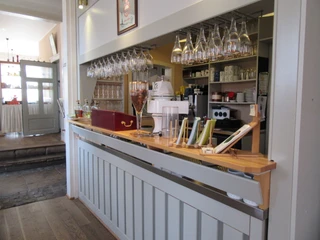 Einladende Theke im Hotel & Restaurant Alte Schule mit stilvoll hängenden Weingläsern und moderner Einrichtung.