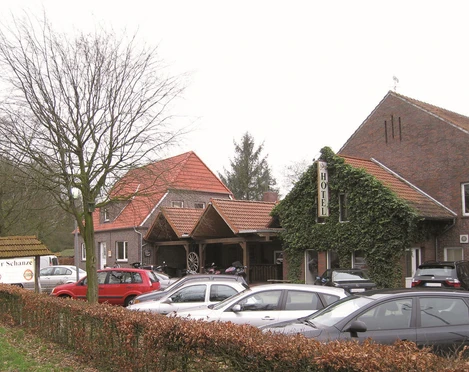 Aussenansicht Gaststätte Zur Schanze Die Außenansicht der Gaststätte "Zur Schanze" zeigt ein einladendes, von Efeu bewachsenes Gebäude mit Parkplätze davor.