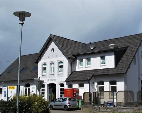 Gleis 3 im Bahnhof Augustfehn Der Bahnhof Augustfehn zeigt ein Gebäude mit weißer Fassade und schwarzem Schieferdach.