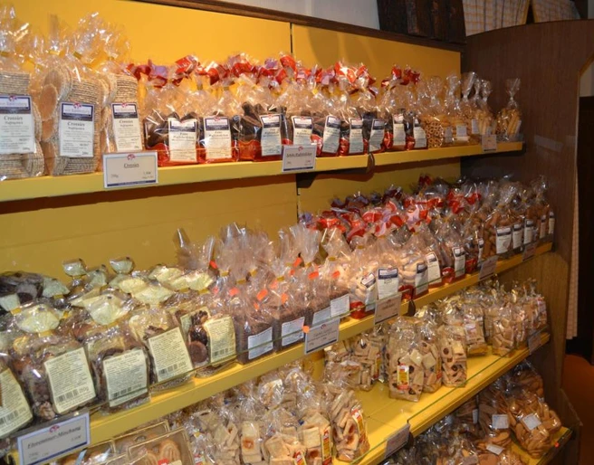 Keksgalerie im Schulze Ladencafé, Borgholzhausen Verschiedene Sorten von Keksen in durchsichtigen Tüten auf gelben Regalen in einem Ladencafé.