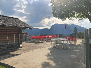 Terrasse de l'auberge Gässsweid Betonierte Terrasse mit roten Tischen und Gartenstühlen Concreted terrace with red tables and garden chairsTerrasse bétonnée avec tables et chaises de jardin rouges
