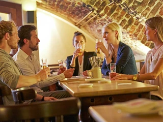 Früh am Dom Eine Gruppe von Menschen sitzt im Gewölbekeller des Brauhauses.A group of people are sitting in the vaulted cellar of the brewery.