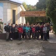Wandergruppe vor dem Restaurant & Café Am Steinbruch in Hilter Eine Wandergruppe posiert fröhlich vor dem Restaurant & Café Am Steinbruch in Hilter im Freien.