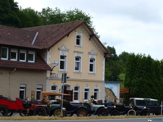 Restaurant & Café Am Steinbruch Historisches Gebäude im Grünen mit Oldtimern vor der Fassade, ideal für nostalgische Erlebnisse.