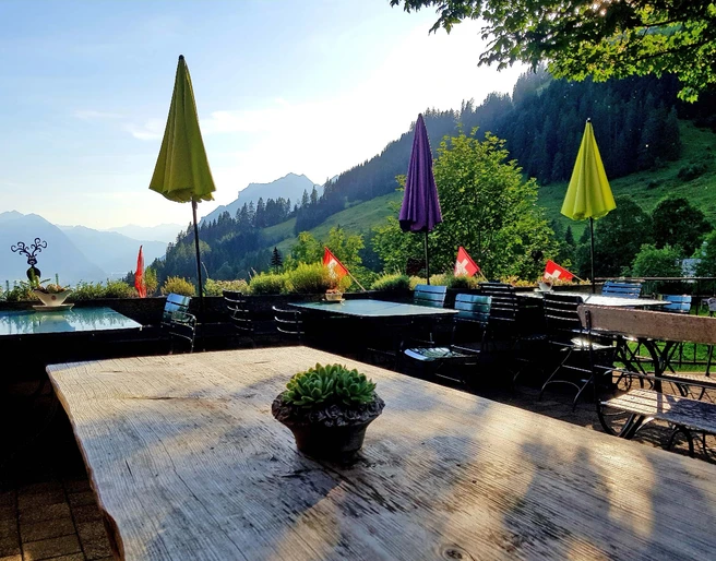 berghaus-planalp-terrasse-tische-sommerabend