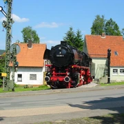 Historische Dampflok 044-389-5 steht auf Gleisstück vor Fachwerkhäusern in Altenbeken.