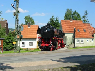 Historische Dampflok 044-389-5 steht auf Gleisstück vor Fachwerkhäusern in Altenbeken.