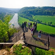 Aussichtsplattform Weser-Skywalk Eine Gruppe von Menschen steht auf einer Aussichtsplattform, die über das Tal der Weser ragt.