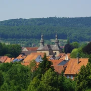Blick auf das Kloster Willebadessen Blick auf das Kloster Willebadessen umgeben von roten Dächern und grüner bewaldeter Hügellandschaft.
