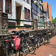 Altstadt Vlotho Fahrräder lehnen an einer Steinmauer in Vlotho vor Fachwerkhäusern mit roten Ziegeldächern.