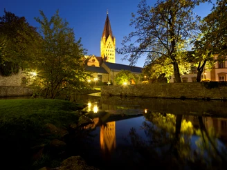 Blick auf Dom, Kaiserpfalz und Dielenpader Abendlicher Blick auf den angestrahlten Dom, Kaiserpfalz und Dielenpader, gespiegelt im ruhigen Wasser.