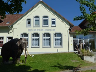Das Heimatmuseum Löhne präsentiert ein historisches Gebäude mit einem Modell eines Mammuts davor.