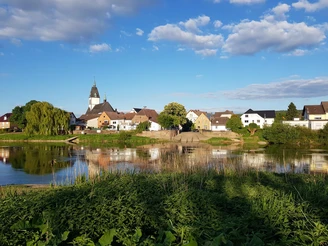 5_weserradweg_blickaufluechtringen_hx2_stephanberg Blick auf das malerische Lüchtringen mit Kirche, Fachwerkhäusern und der Weser im Vordergrund.